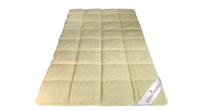 Elegante, cremefarbene Decke mit kariertem Muster, die mit einem "Royal Dream"-Etikett versehen ist.