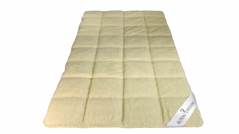 Beige, rechteckige Matratzenauflage mit einem karierten Muster und einem weißen Etikett mit der Aufschrift "Royal Dream" an einer Ecke.