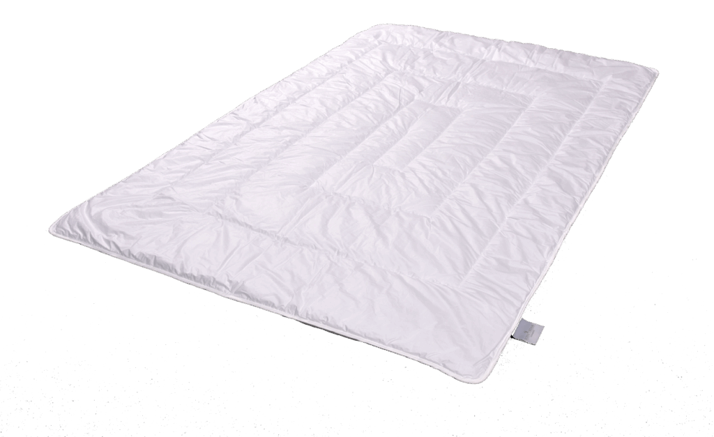 Eine weiße, gesteppten Bettdecke mit einem rechteckigen Muster auf schwarzem Hintergrund.