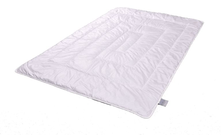 Eine weiße, gesteppten Bettdecke mit einem rechteckigen Muster auf schwarzem Hintergrund.