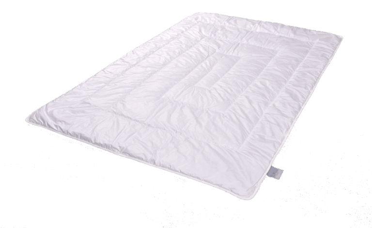 Eine weiße gesteppte Bettdecke auf einem neutralen Hintergrund.